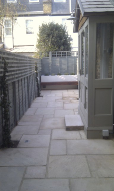 mint-sandstone-paving-patio-with-olive-green-fence-and-trellis-london-small-garden.jpg