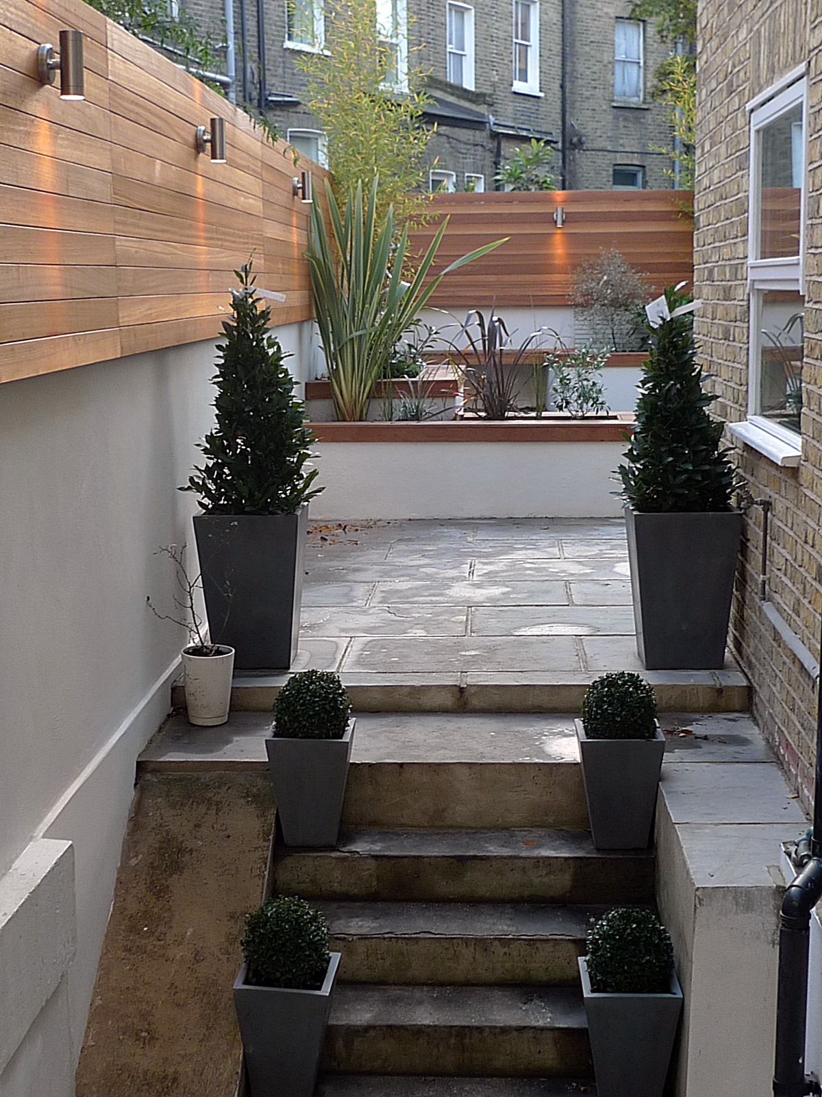 modern london courtyard low maintenance urban outdoor indoor living garden space paving screens planting bench raised beds (1)