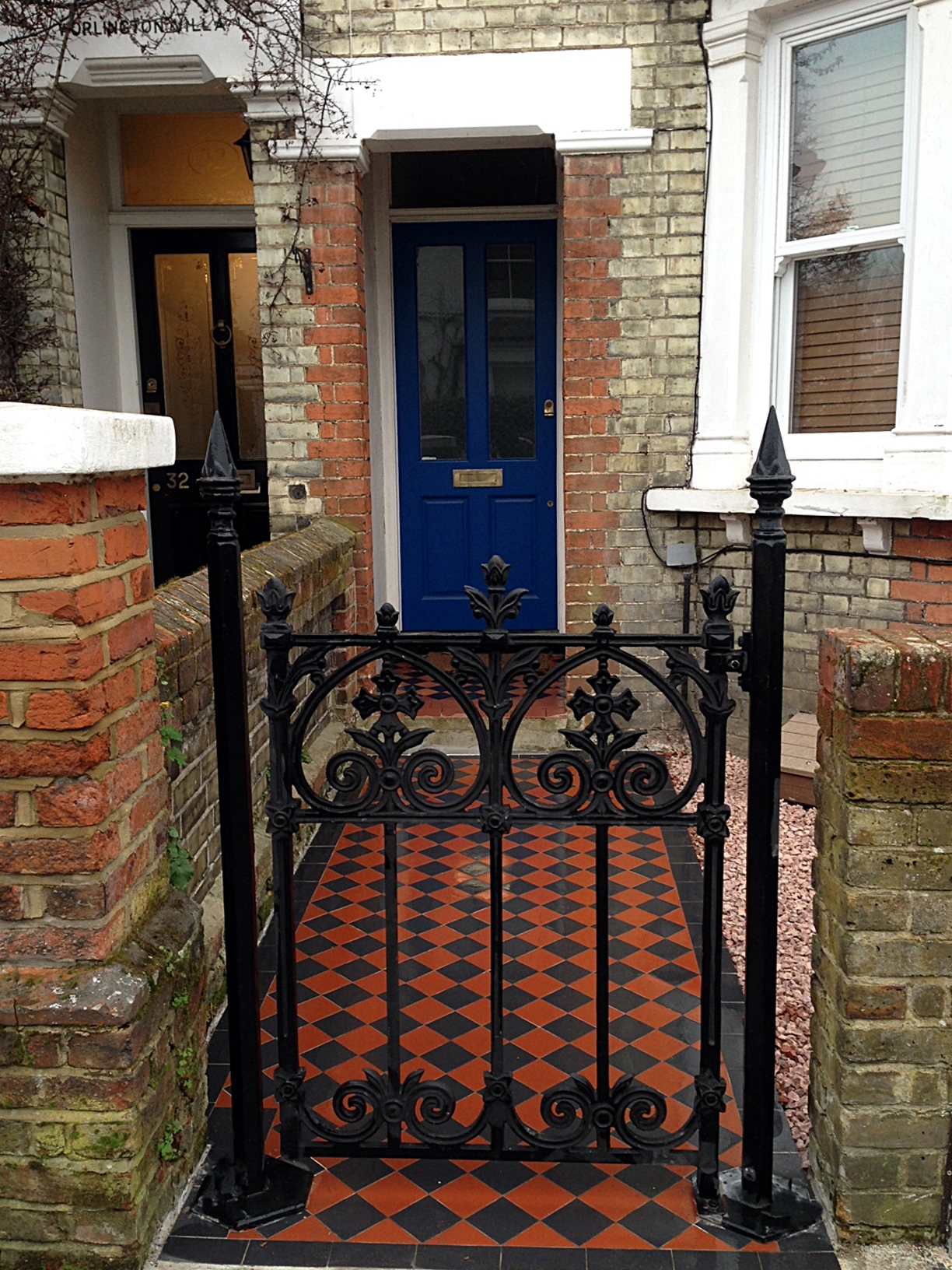 wrought iron gate and brick garden wall victorian mosaic tile path south west london
