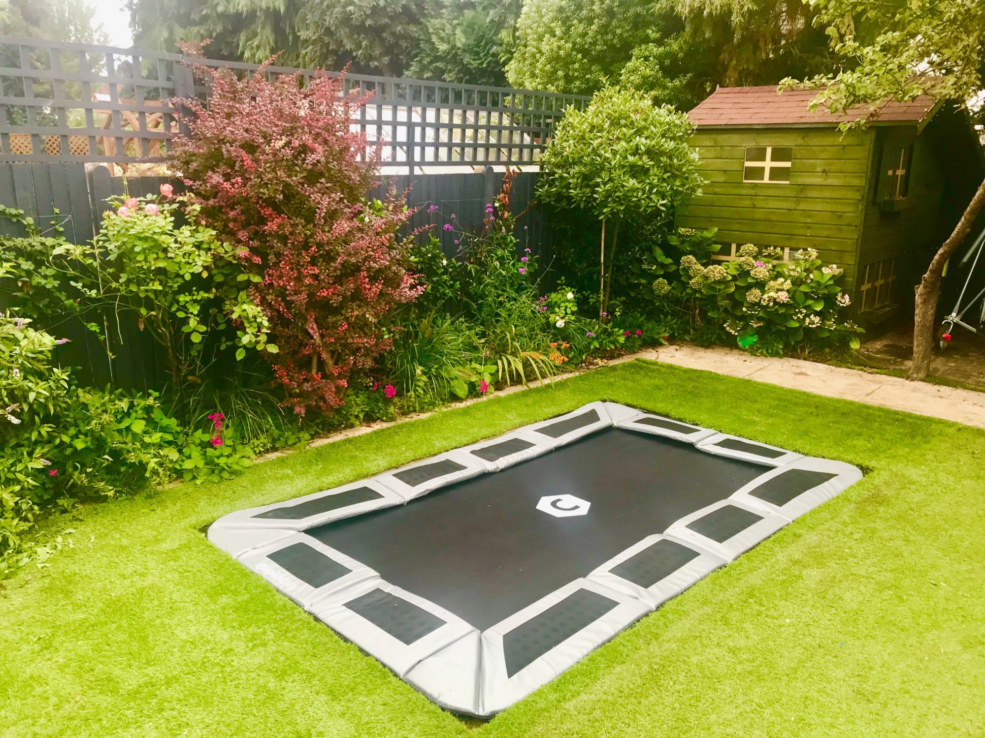 Sunken trampoline with artificial grass and optional lid design and