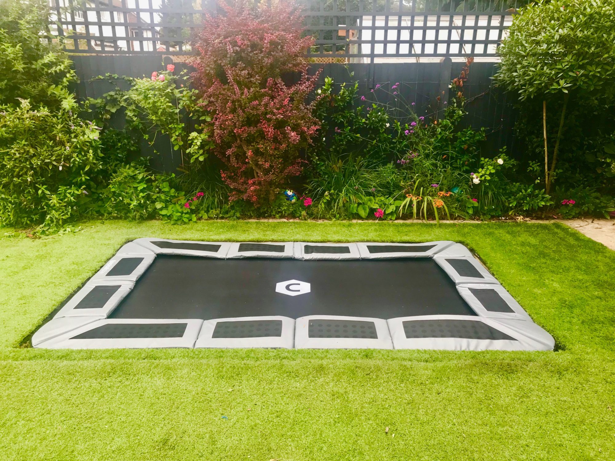 Sunken trampoline with artificial grass and optional lid design and