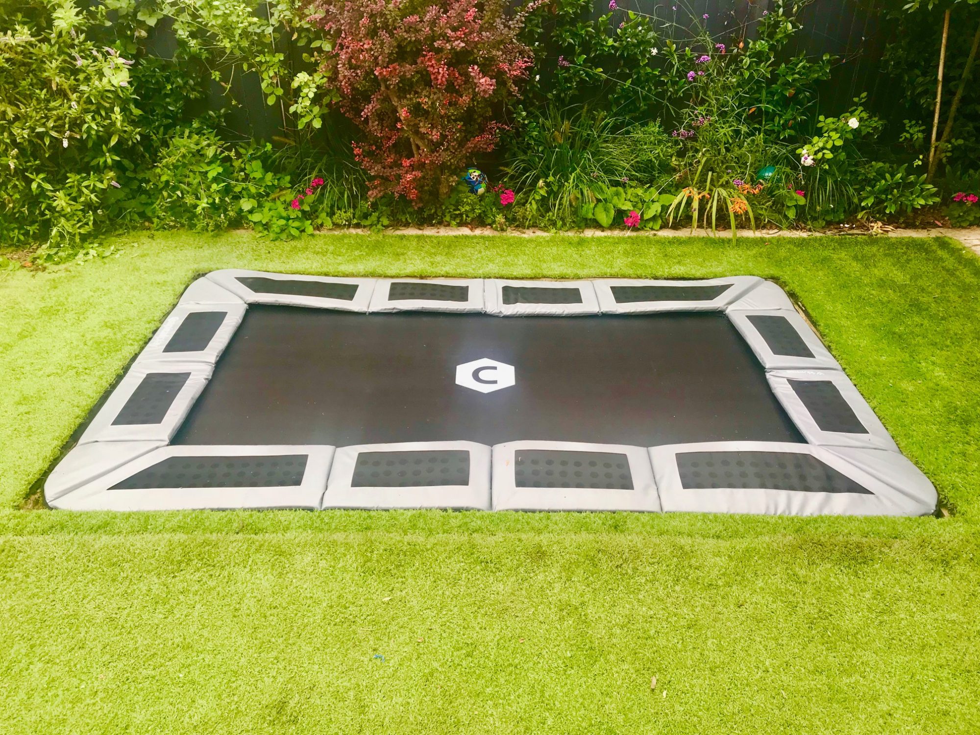 Sunken trampoline with artificial grass and optional lid design and